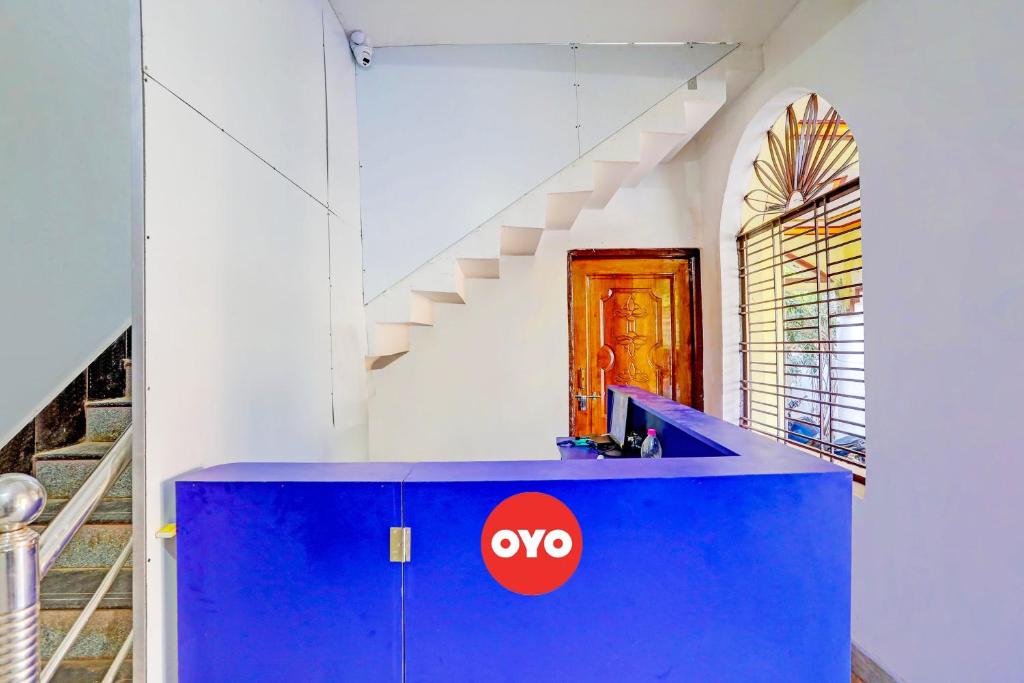 un bancone blu con sopra un cartello aorto in una stanza con scale di Super OYO Flagship Namaskar Cozzy Cottage a Bhubaneshwar