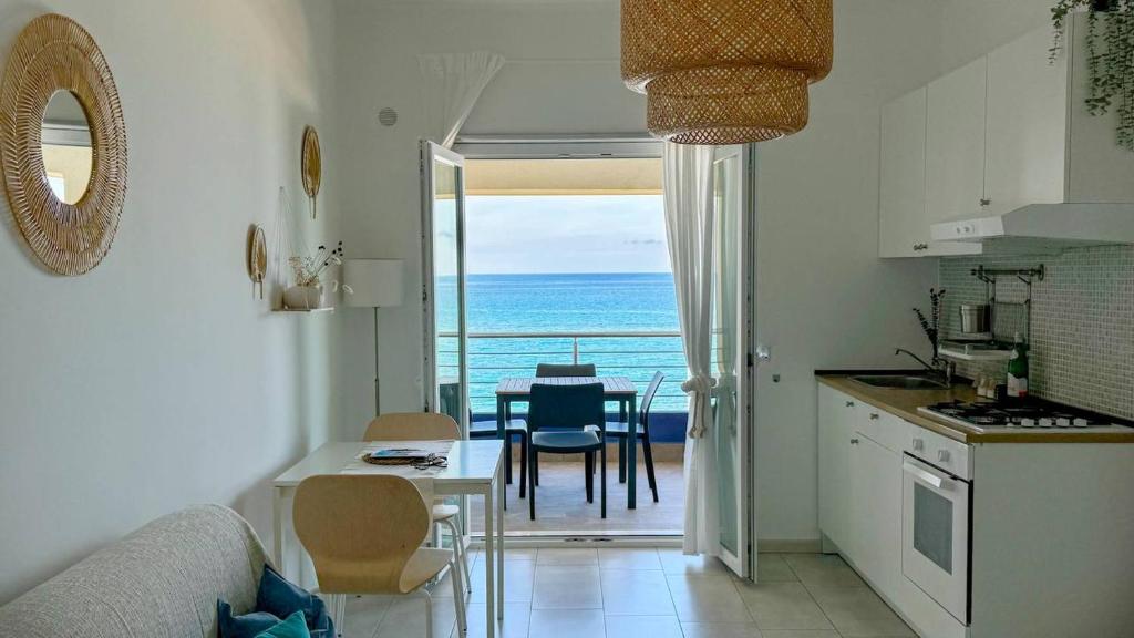 ヴィッラフランカ・ティッレーナにあるAppartamenti Vacanze Villa Meoのキッチン、海の景色を望むダイニングルーム
