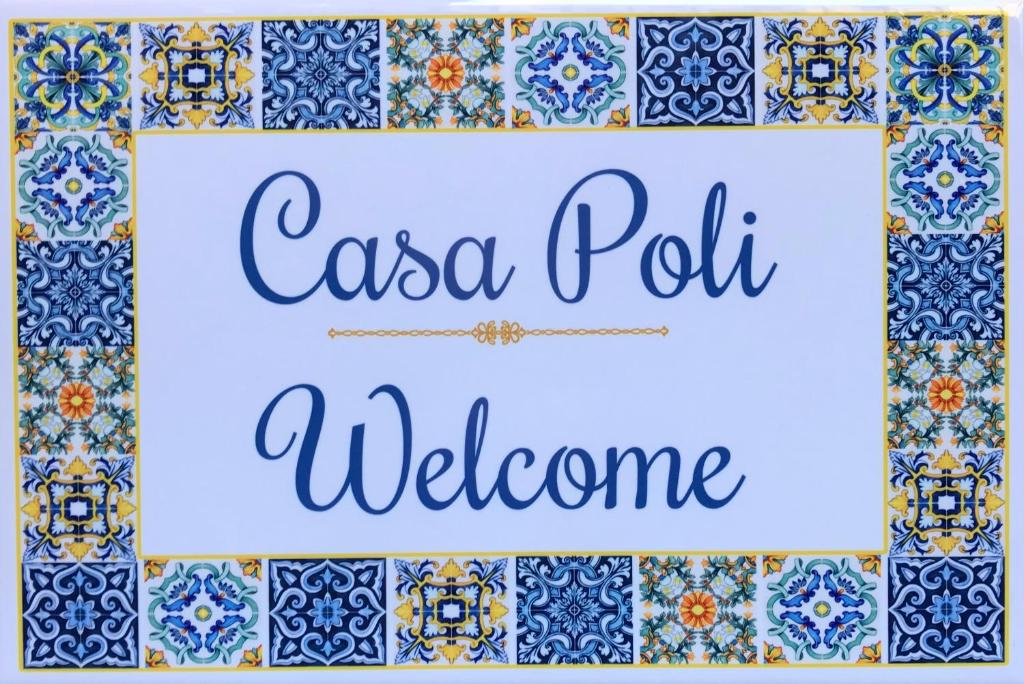 um sinal que diz casa pola bem-vindo em uma parede de azulejos em Casa poli em Portici