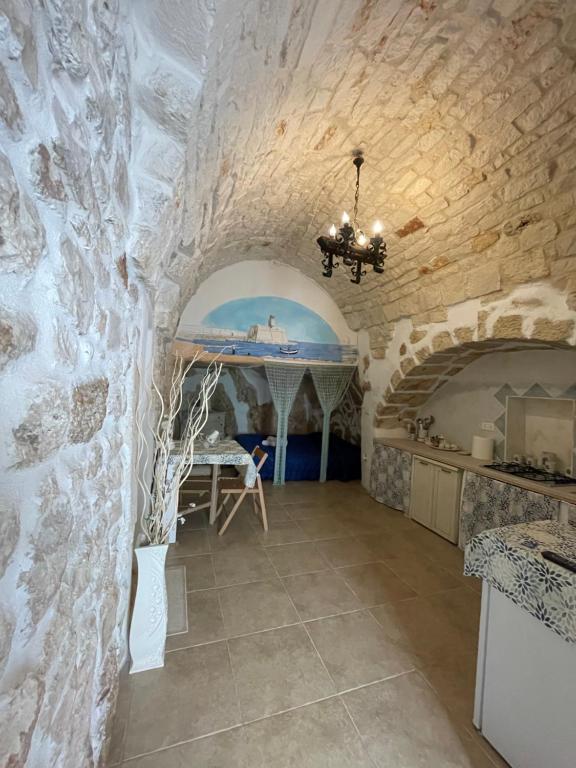 奧斯圖尼的住宿－Casa Mimmo，厨房设有石墙和桌子