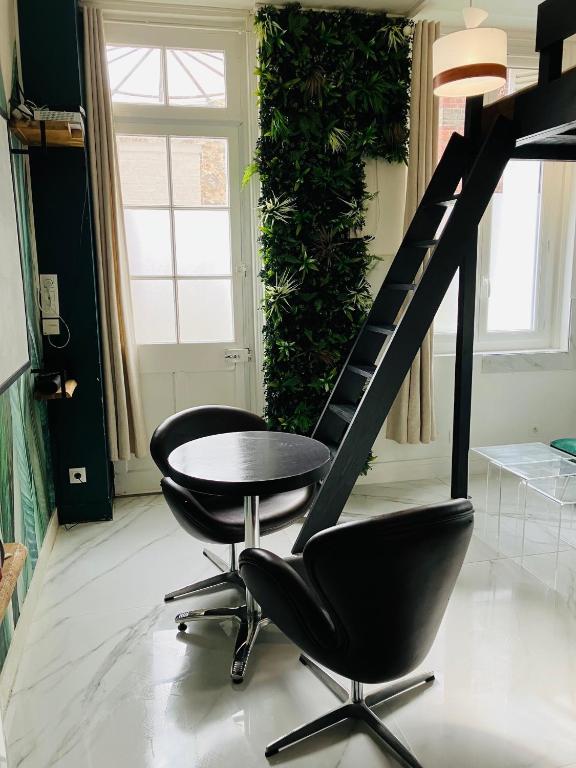 une chambre avec deux chaises, une table et un escalier dans l'établissement Studio Mezzanine, à Rouen