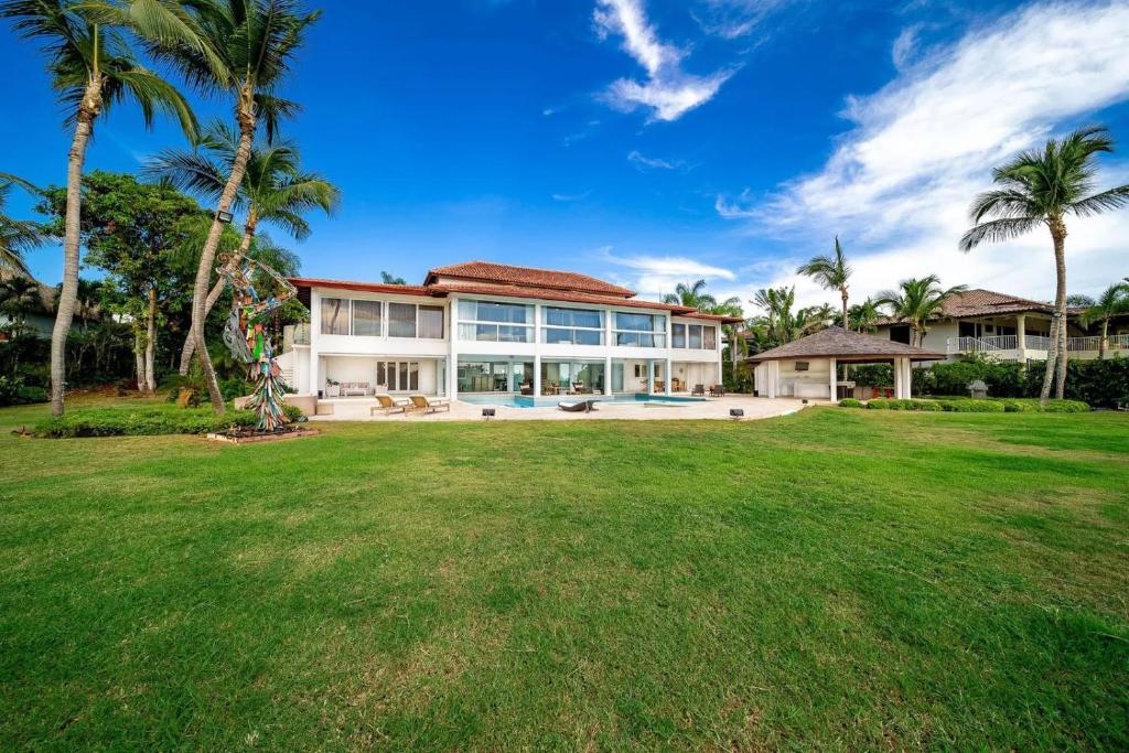 an exterior view of a large house with a yard at Casa de Campo Elegance - 8-Bedroom Golf View Villa in La Romana