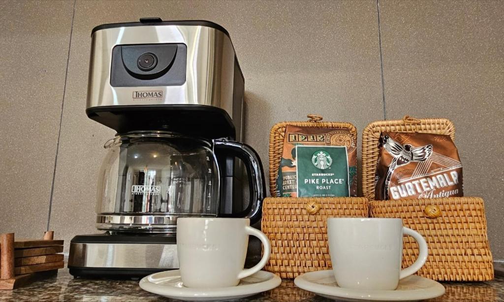 dos tazas de café en una barra con cafetera en Jardines del Pacífico 3, en La Serena