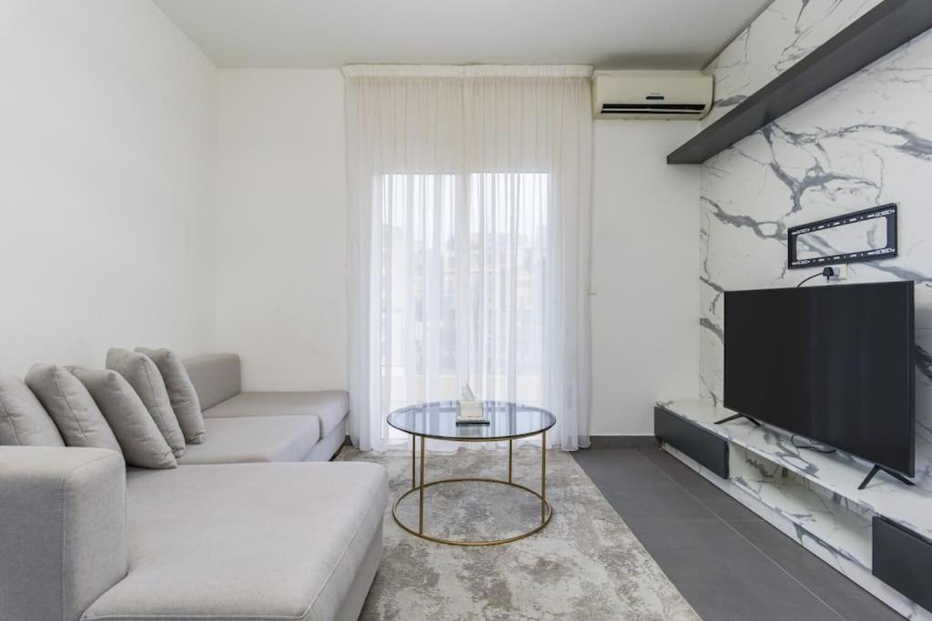 a living room with a couch and a tv at Luna 2-BR in Mar Mikhael in Beirut