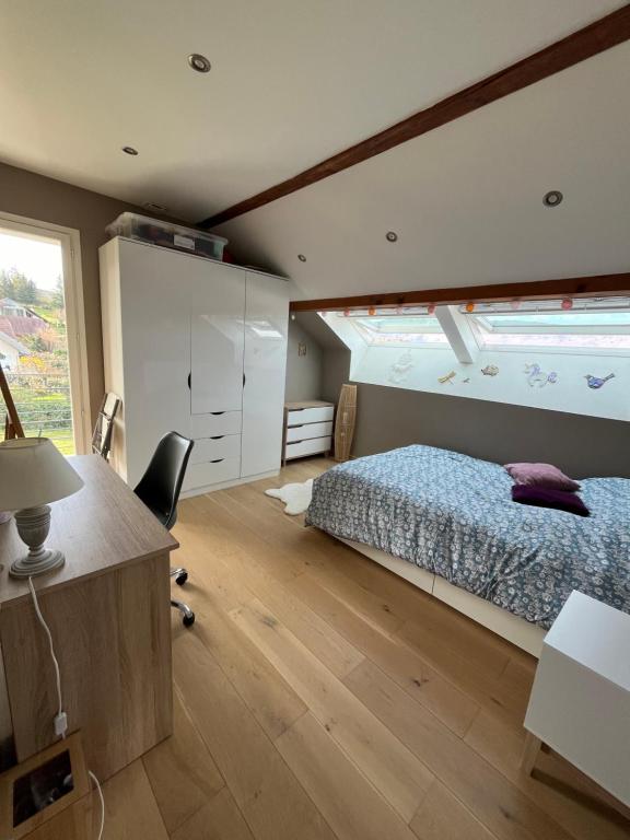 una camera con letto, scrivania e finestra di La Cadamale a Menthon-Saint-Bernard