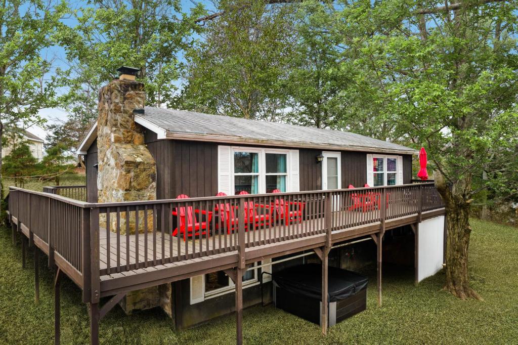 una casa en una terraza con chimenea de piedra en Cabin w Hot Tub Fireplace 5 min walk to Downtown, en Berkeley Springs