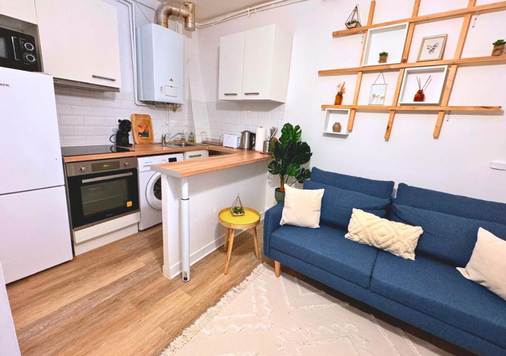 un salon avec un canapé bleu dans une cuisine dans l'établissement T2 chic & cosy, RER D, Orly 15 min, à Villeneuve-Saint-Georges