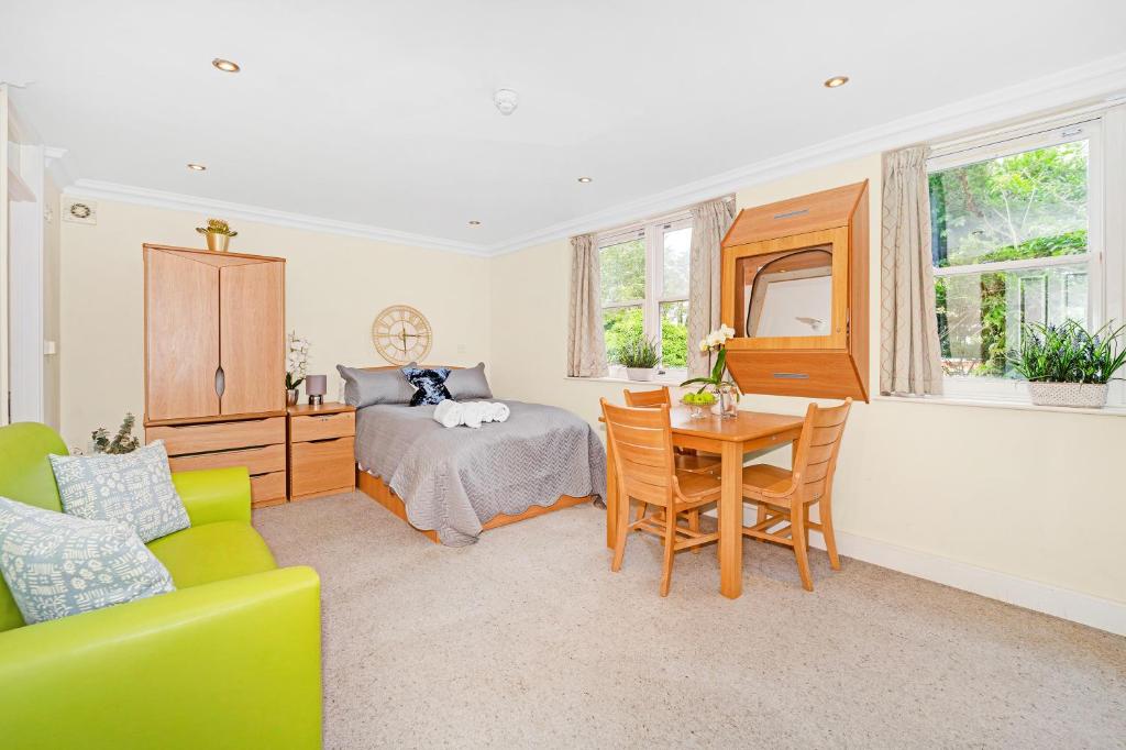 a bedroom with a bed and a table and chairs at Park Views Apartments in Teddington