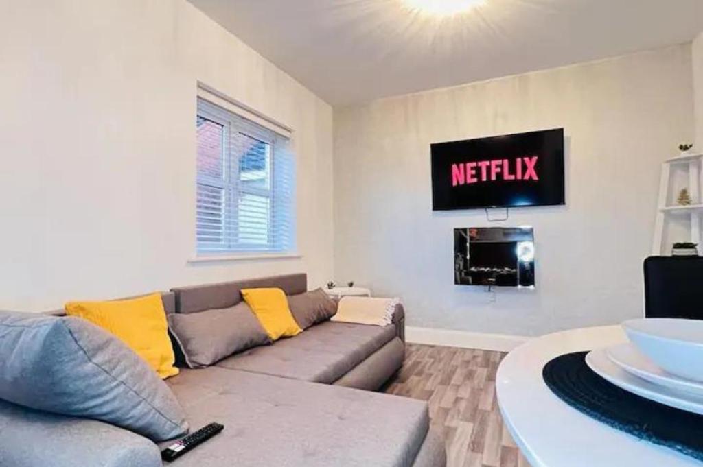 a living room with a couch and a tv at Ava's Apartment - 1 Bedroom In Solihull Centre - Free Parking - Wi-Fi in Solihull