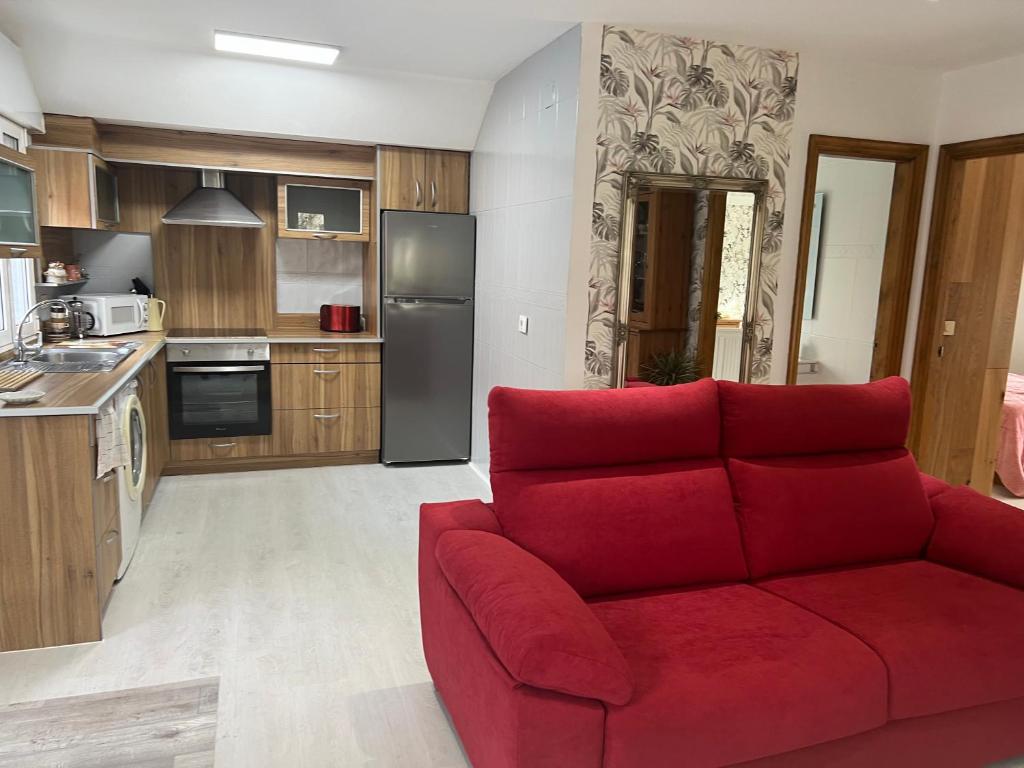 een woonkamer met een rode bank in een keuken bij Casa Carmen As Airas in Ourense