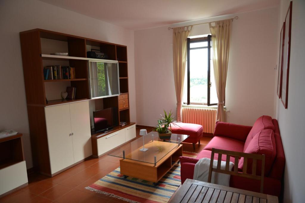 un soggiorno con divano rosso e tavolino da caffè di Casa Sant'Anna a Ozzano Monferrato