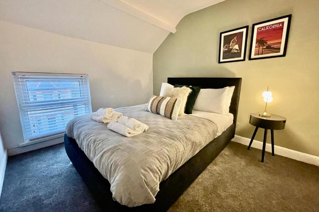 a bedroom with a bed with towels on it at Sophia's Retreat - 2 Floor 4 Bed Apartment - Newport - Coastal Getaway in Newport
