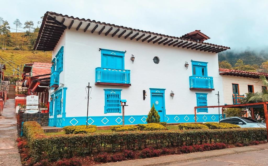 a blue and white house with blue windows and blue shutters at Villa Linda ApartaHotel in Jericó
