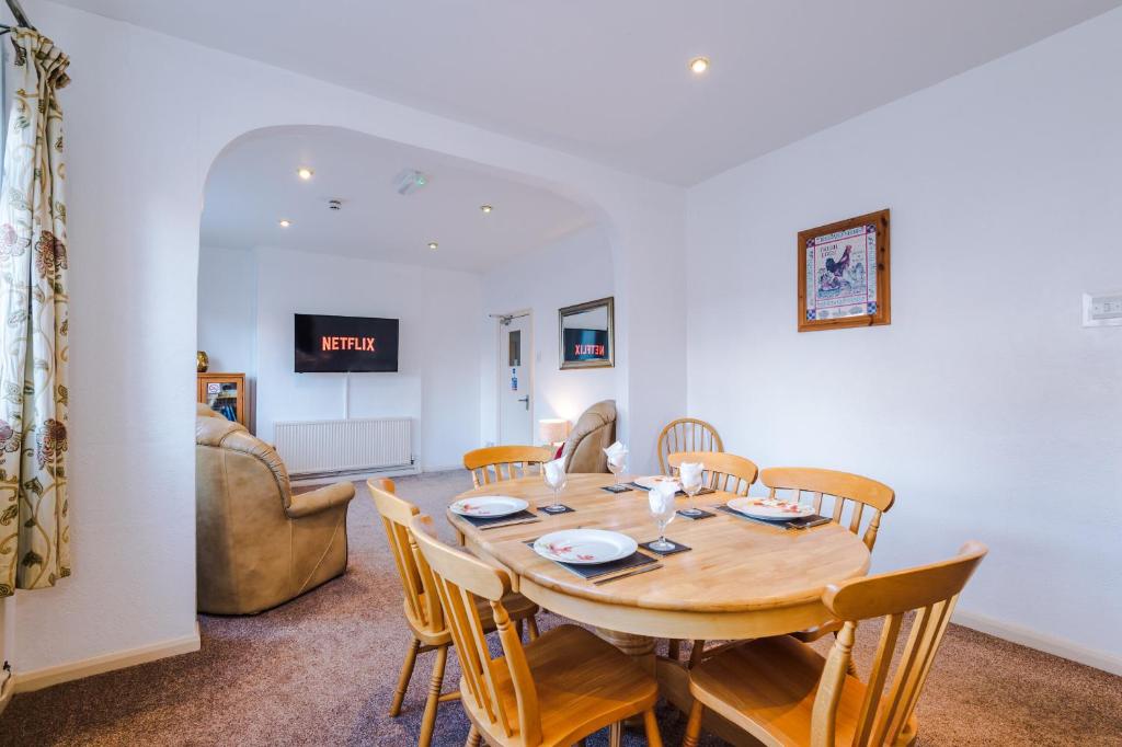 comedor con mesa de madera y sillas en Contractor Accommodation Barnetby en Barnetby le Wold