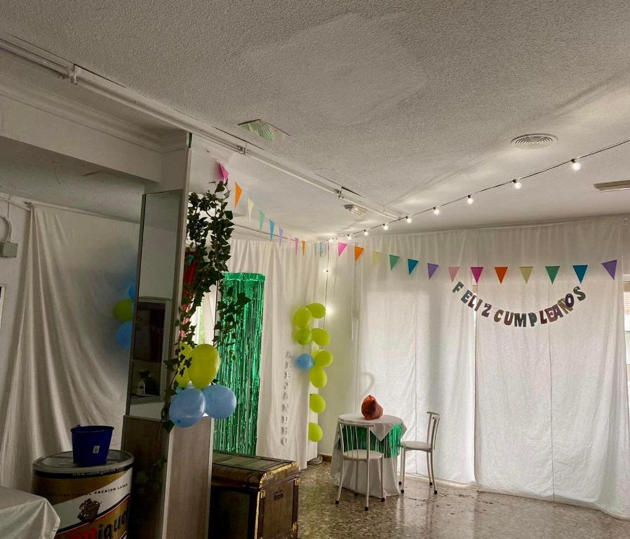 a room with a table with balloons and a curtain at Casa VENTA RUIZO in Lorca