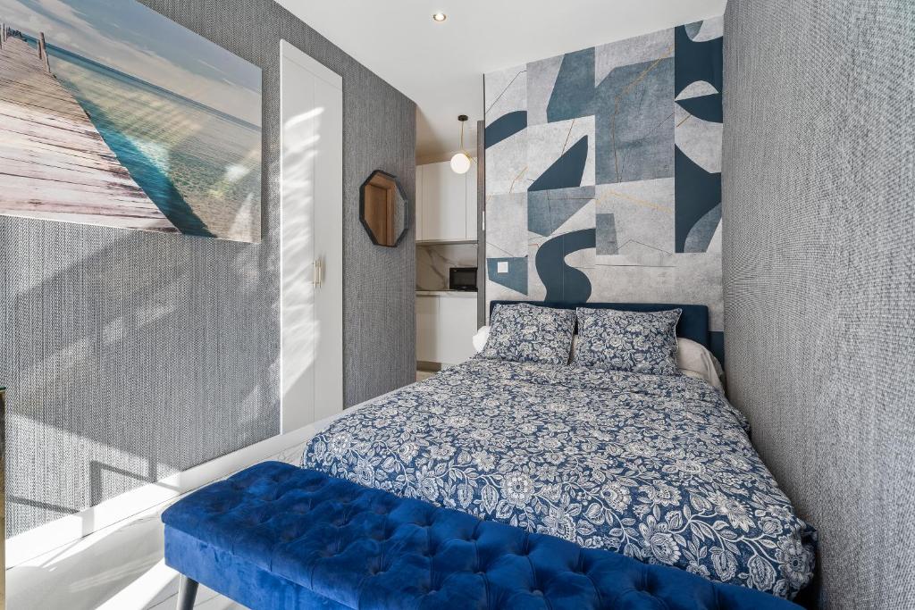 a bedroom with a blue bed and a blue bench at Nice Renting - 6FRANCE - Suite Luxe & Confort Bord de Mer Massena in Nice