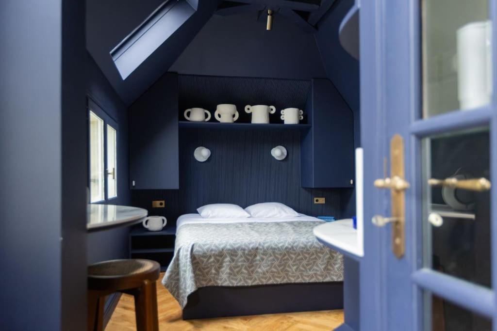 - une chambre bleue avec un lit et un lavabo dans l'établissement Midnight Suite - Marais, à Paris