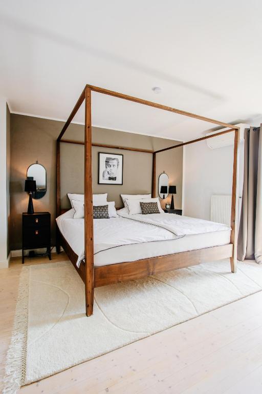 a bedroom with a wooden canopy bed with white sheets at Cottage Salzburg in Nußdorf am Haunsberg