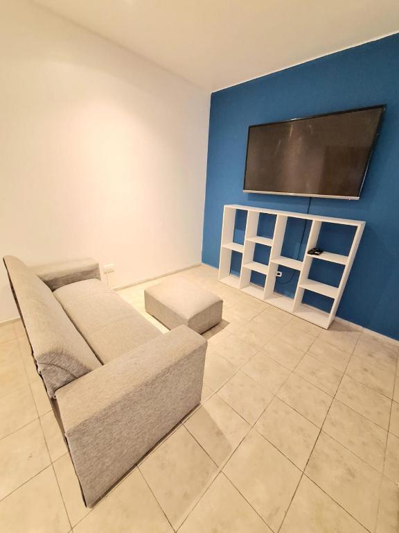 sala de estar con sofá y TV de pantalla plana en Le Bleu Apartamento en Buenos Aires