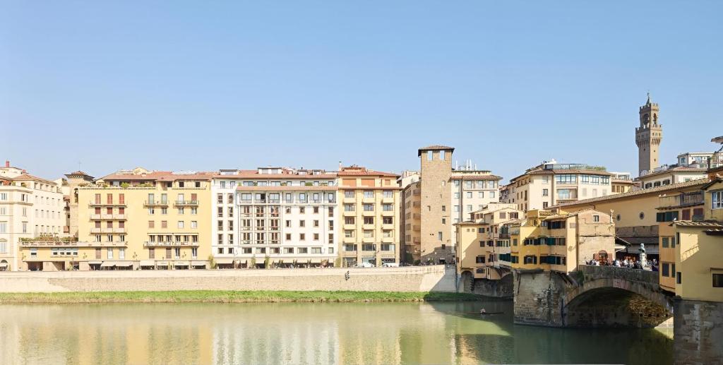 uitzicht op een stad met een rivier en gebouwen bij Ponte Vecchio Escape Suite in Florence