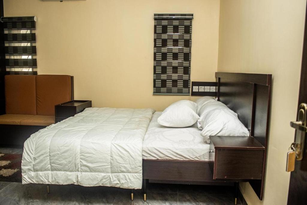 a bedroom with a bed with two pillows on it at Studio Room Apartment in Port Harcourt