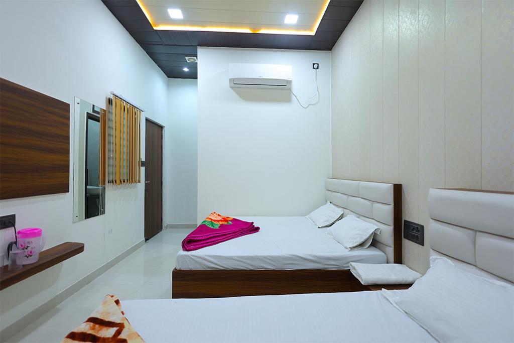 a bedroom with two beds in a room with aperature at Shiv Residency in Mathura