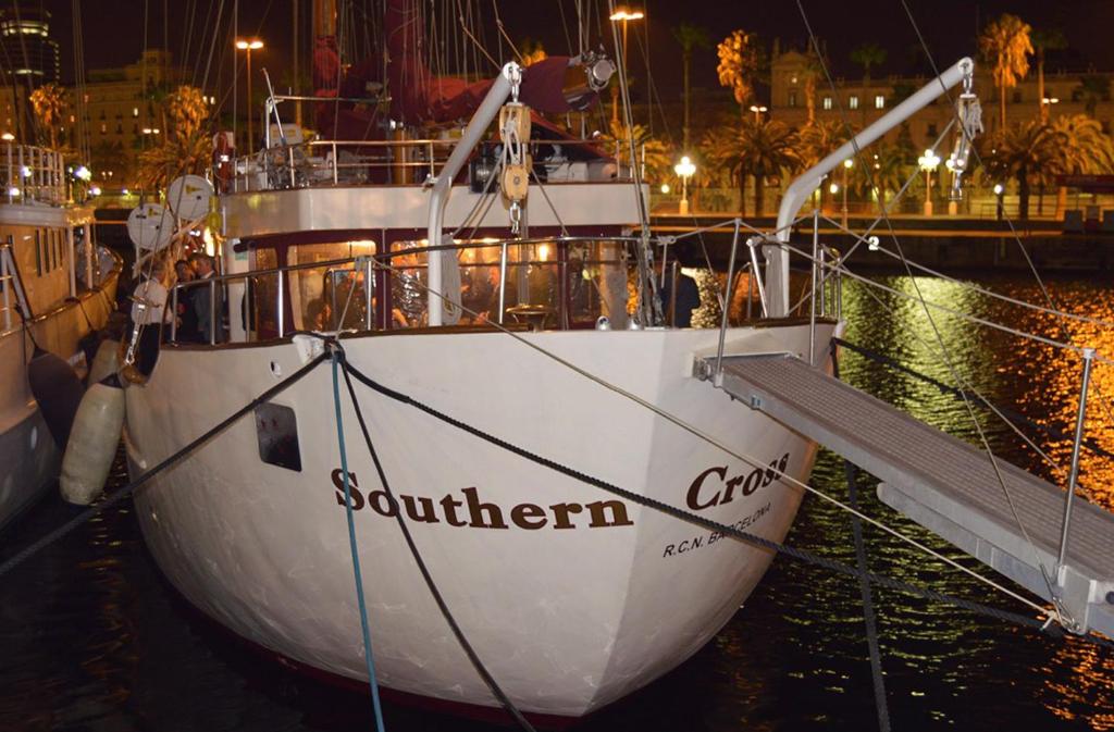 a white boat docked in the water at night at Southern Cross in Barcelona