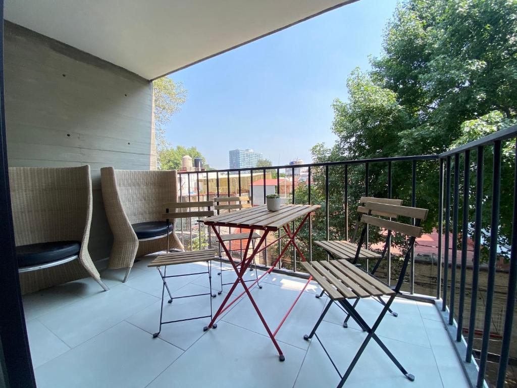 patio con mesa y sillas en el balcón en Moderno Departamento con terraza pegado a la condesa, en Ciudad de México