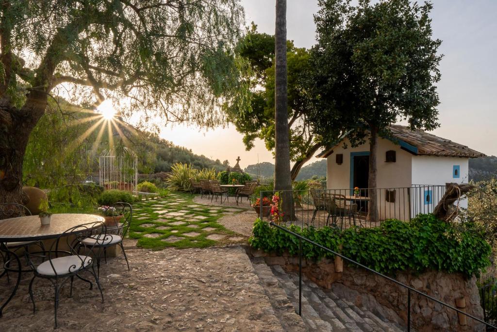 a patio with tables and chairs and the sun setting at Ca's Xorc Luxury Retreat - ADULTS ONLY in Sóller