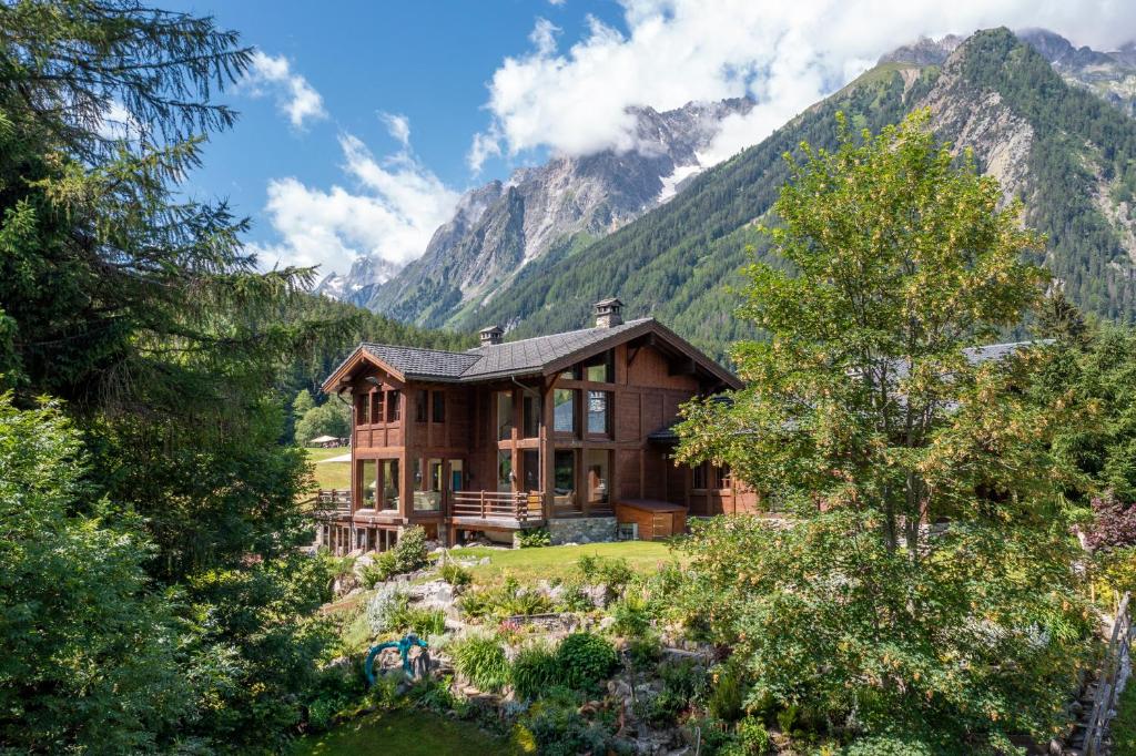 a wooden house with mountains in the background at Chalet Cinq Moutons in Orsières
