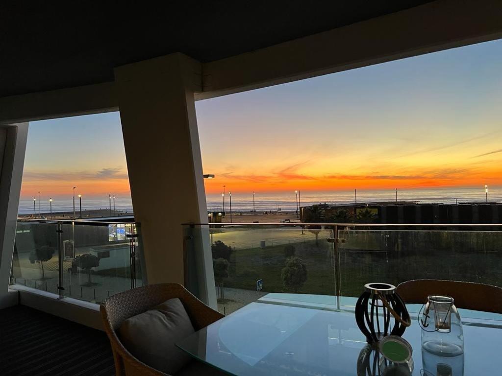 um quarto com uma mesa e vista para o oceano em luxury Plazza Sea view em Costa da Caparica