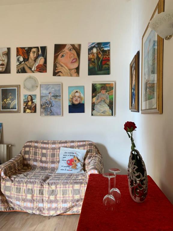 a living room with a couch and pictures on the wall at Appartamento Meri, Montecatini Terme in Montecatini Terme