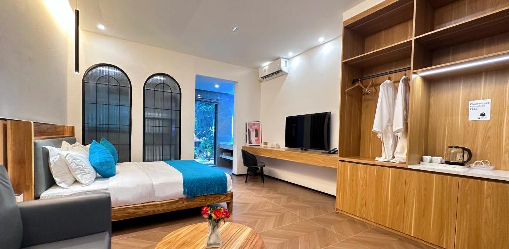 um quarto com uma cama, uma secretária e uma televisão em No 33 Lodge em Dar es Salaam