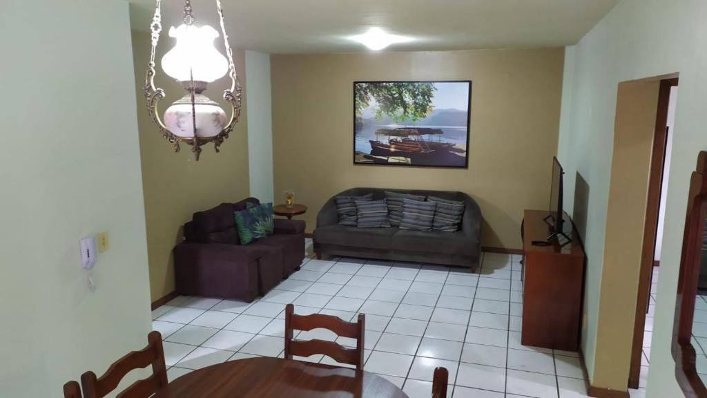 un salon avec un canapé et une table dans l'établissement Apartamento na quadra do mar, à Itapema