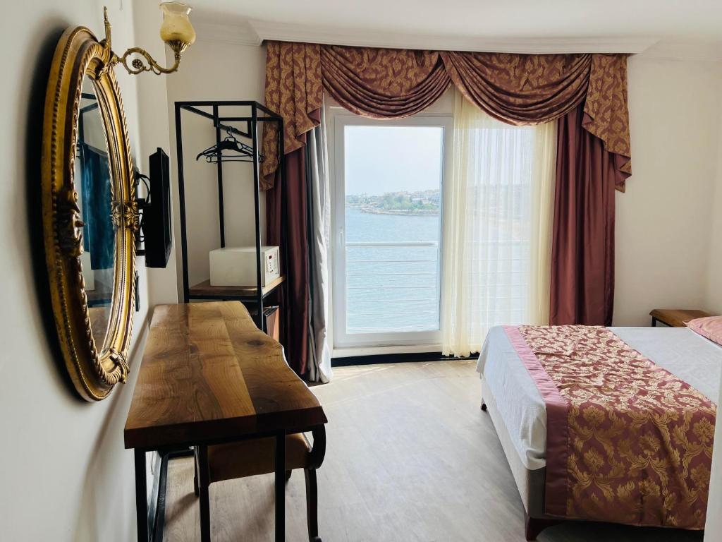1 dormitorio con cama, espejo y ventana en Roxo Beach Hotel, en Erdemli