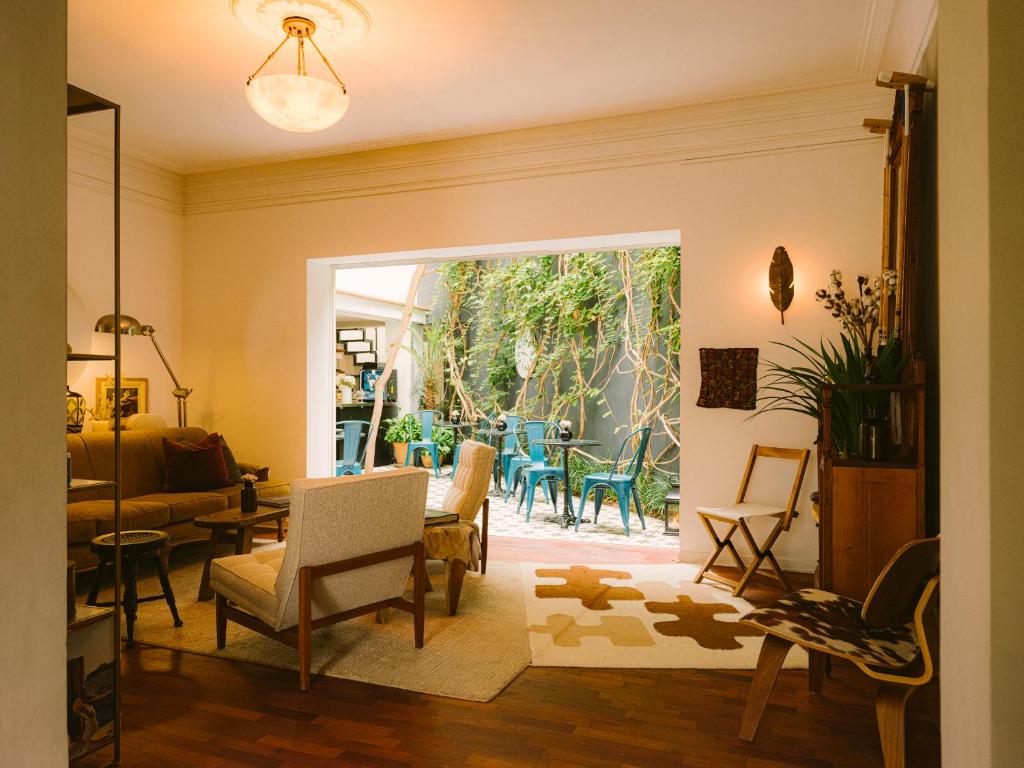 uma sala de estar com cadeiras e um quarto com um pátio em Fausto em Lima
