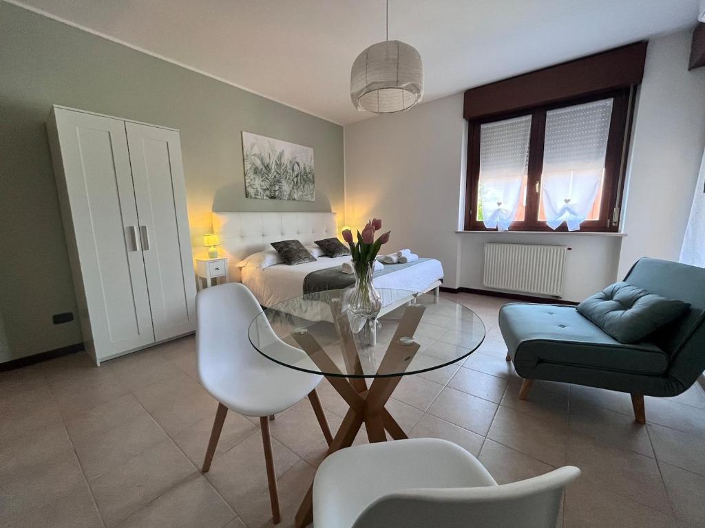 a living room with a glass table and a bedroom at Perla Apartment Verona in Verona