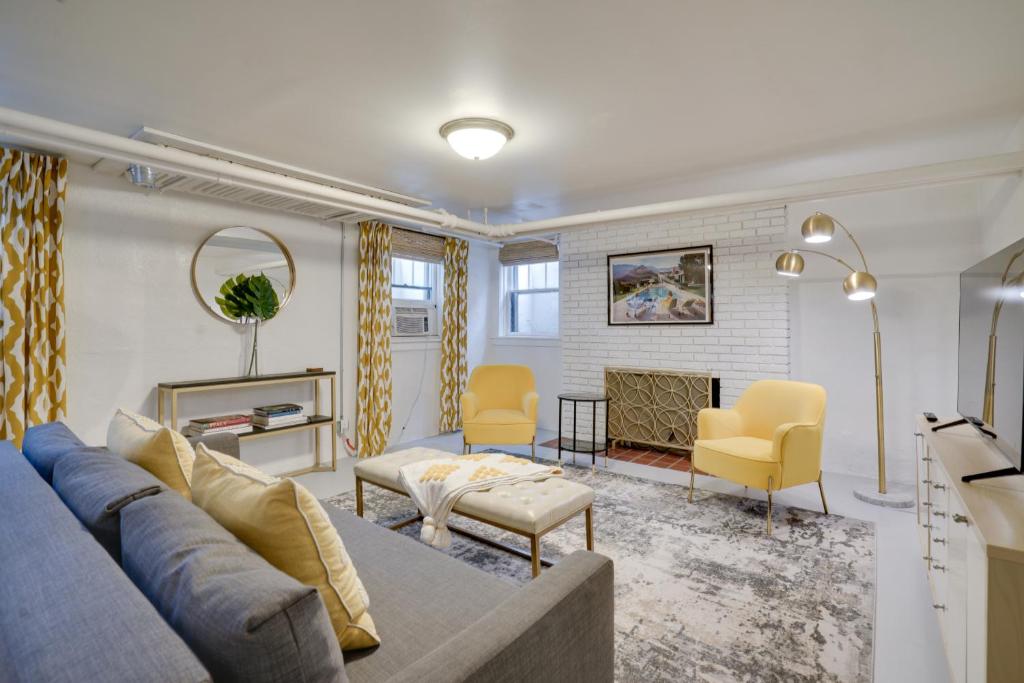 ein Wohnzimmer mit einem blauen Sofa und gelben Stühlen in der Unterkunft Cozy and Chic Minneapolis Home 5 Mi to Dtwn! in Minneapolis