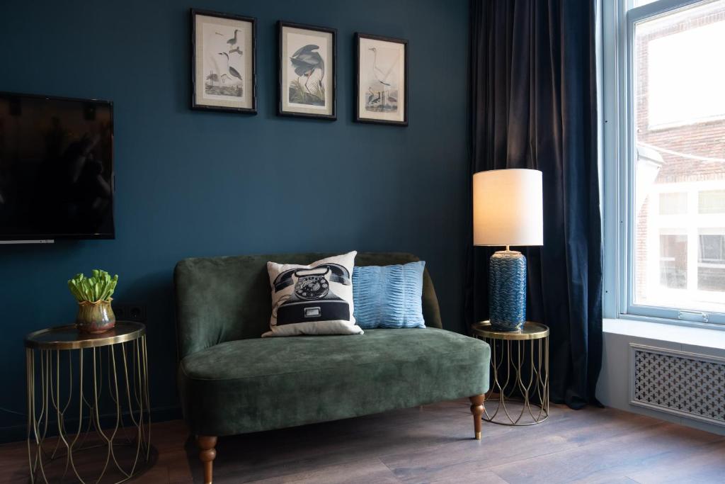 a living room with a green chair and a lamp at Six Boutique Hotel in Haarlem