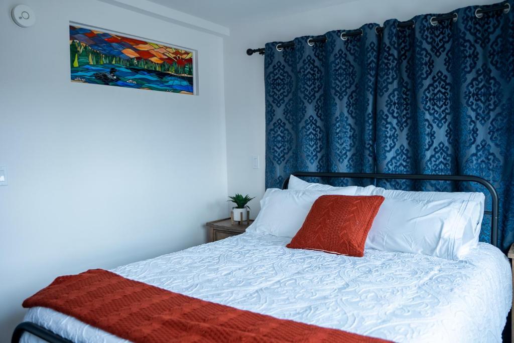 a bedroom with a bed with a blue curtain at Vasanoja Suite 102, Hyland Hotel in Palmer