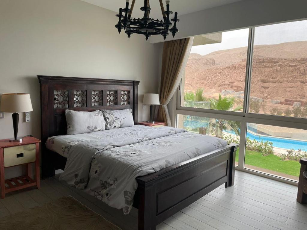 a bedroom with a large bed with a large window at Beautiful chalet in Il Monte Galala المونت جلالة ch15-01-01 in Ain Sokhna