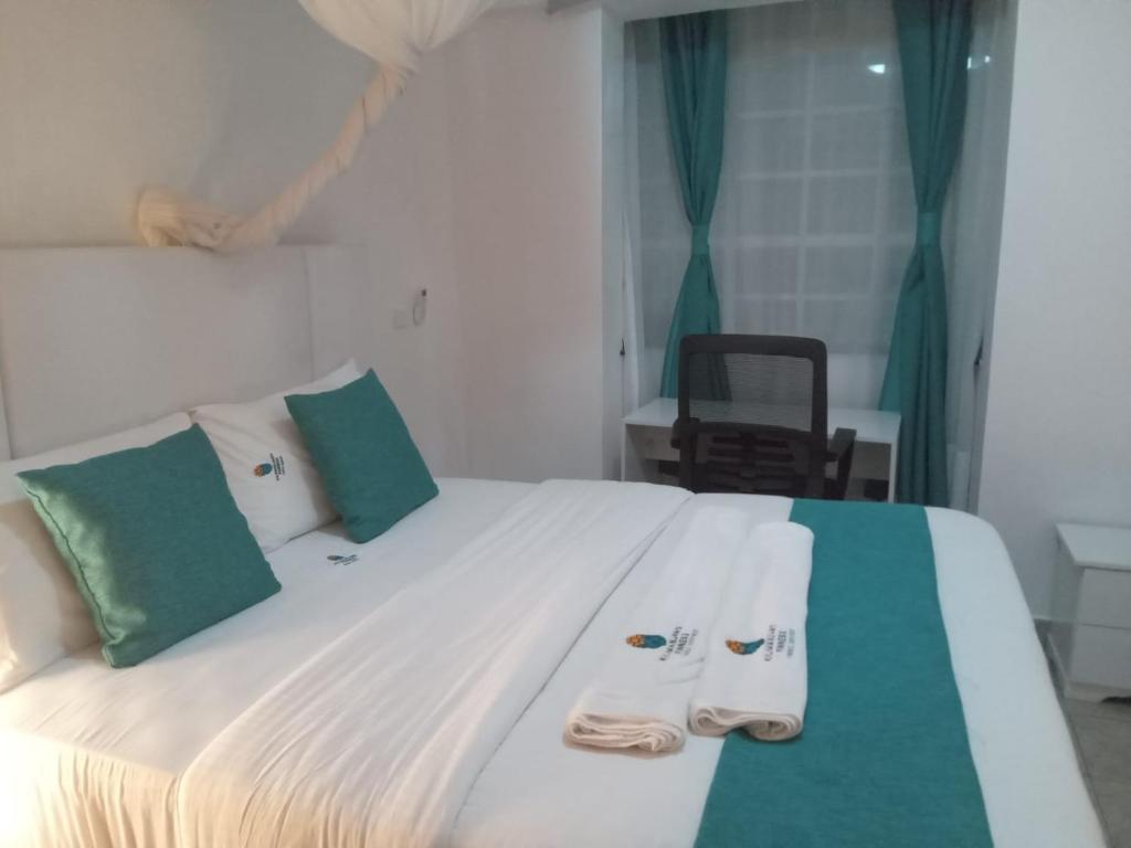 ein Schlafzimmer mit einem Bett mit zwei Hausschuhen darauf in der Unterkunft Kilimanjaro Hansel with Aircon (1 BR) in Kisumu