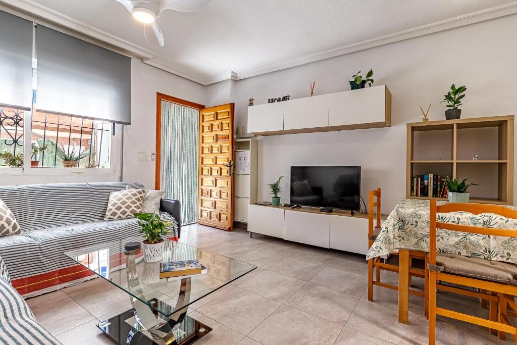 ロス・アルカサレスにあるCasa Jansiver - 450m de la playa, céntrica pero tranquilaのソファとテレビのあるリビングルーム