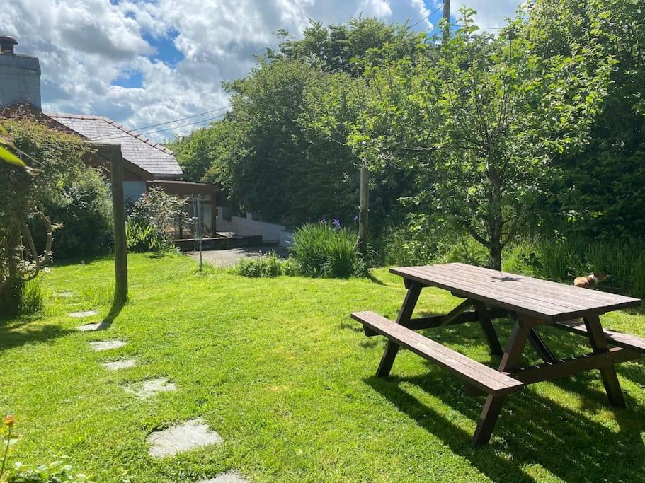 - une table de pique-nique en bois assise dans l'herbe dans l'établissement Quirky Cottage with Private Garden Nr New Quay Cardigan Bay, à Llandysul