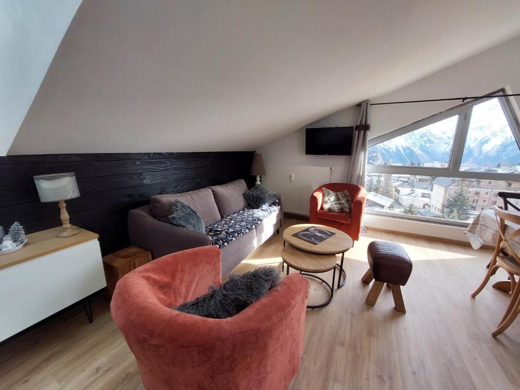 uma sala de estar com um sofá e cadeiras e uma janela em Appartement Les Deux Alpes, 2 pièces, 6 personnes - FR-1-516-93 em Les Deux Alpes