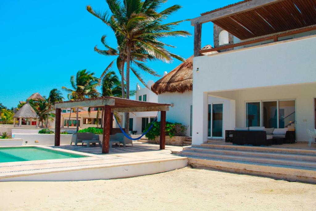 una casa con una piscina y una palmera en Nisiros Spacious Beachfront home, en Chicxulub
