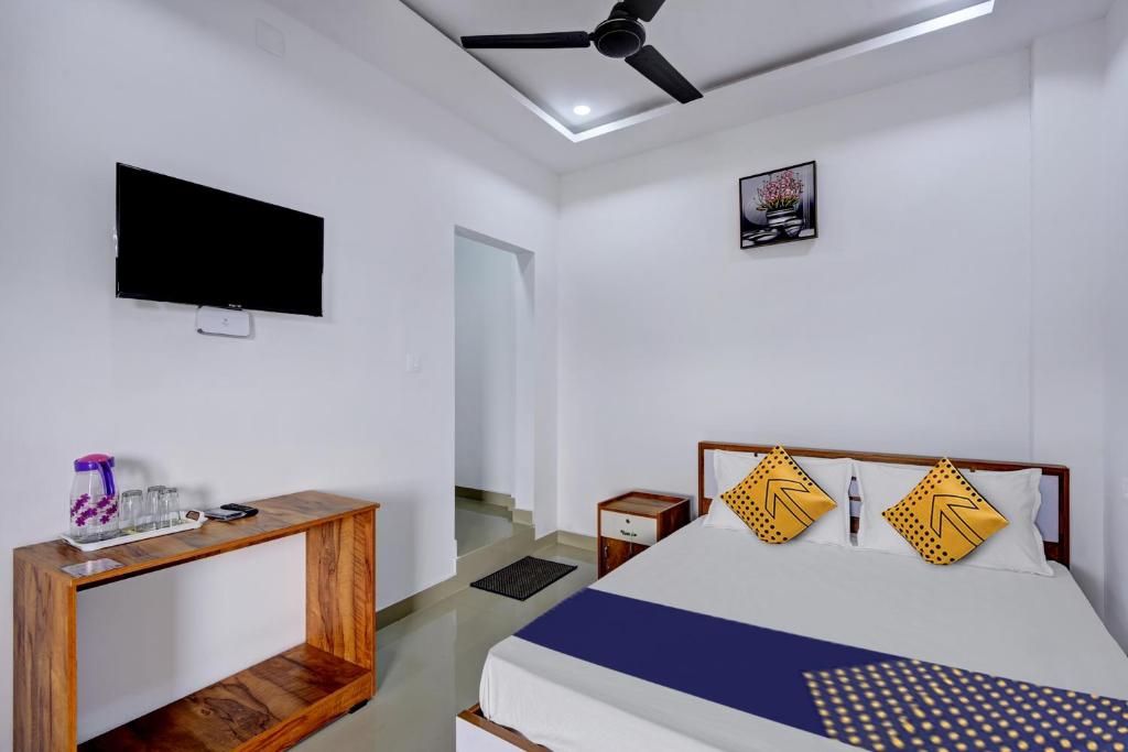 a bedroom with a bed and a flat screen tv at Hotel Aqua Palace Inn in Kannur