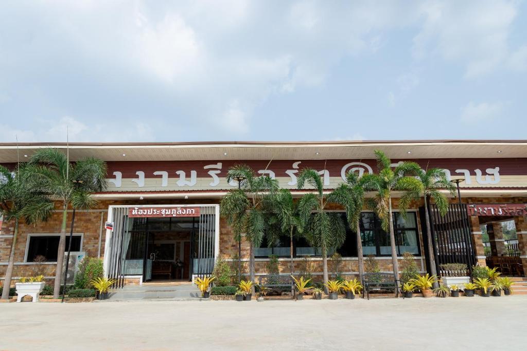 um edifício com palmeiras em frente em Buengngarm Resort 