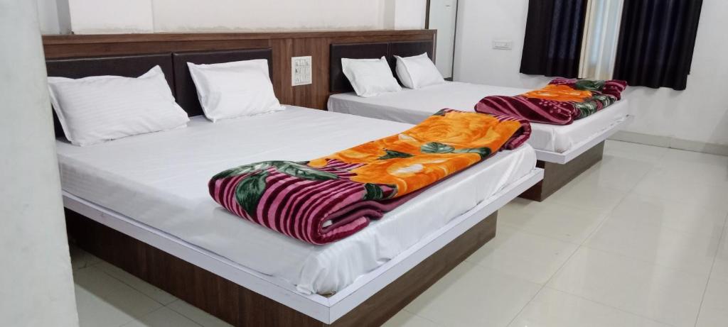 two twin beds in a room at Hotel Shri Bhanwardeep in Nāthdwāra