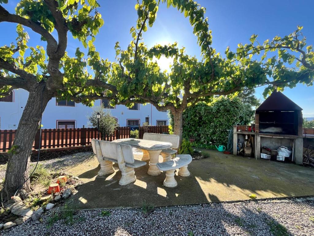 een witte tafel en stoelen in een tuin met bomen bij Cal Muntanyès in Barcelona